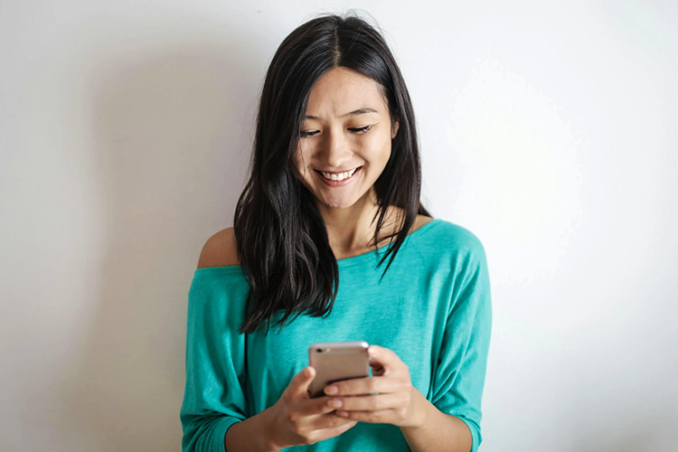 ragazza sorridente che utilizza uno smartphone