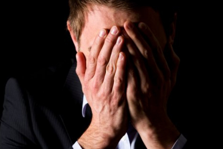 Dettaglio della locandina Dettaglio della locandina: uomo che si copre il viso con le mani
